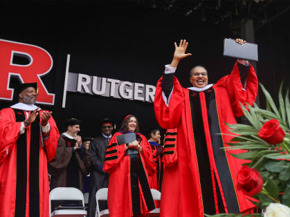 Freeman Hrabowski standing with his hands raised on the state at Rutgers commencement